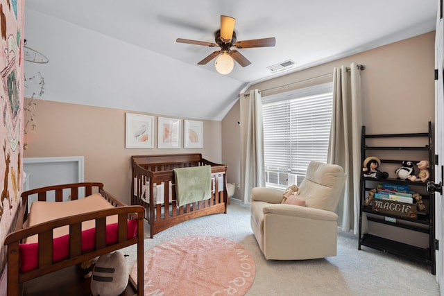 carpeted bedroom featuring a crib, ceiling fan, and lofted ceiling