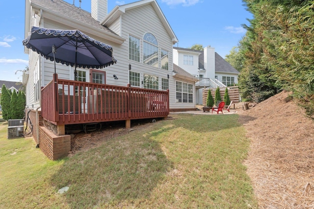 rear view of property with a wooden deck, a yard, cooling unit, and a patio