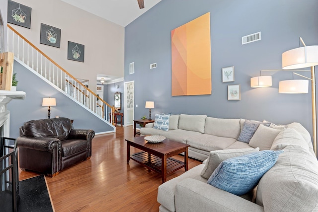 living room featuring hardwood / wood-style flooring and a towering ceiling