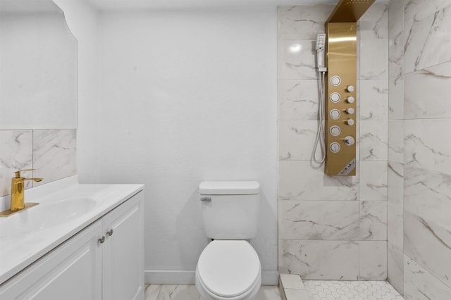 bathroom featuring a tile shower, vanity, and toilet