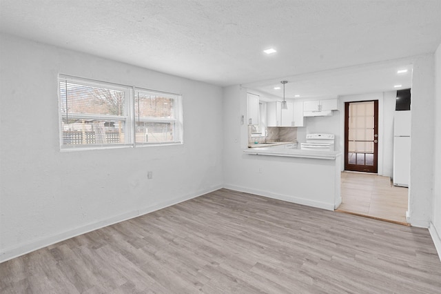 unfurnished living room with sink, a textured ceiling, and light hardwood / wood-style flooring