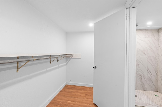 walk in closet with light hardwood / wood-style floors