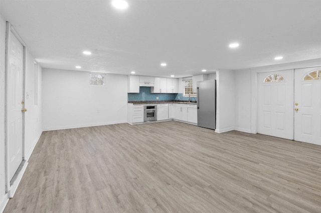 unfurnished living room with light hardwood / wood-style floors and sink