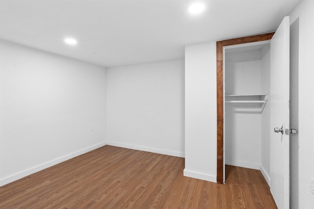 unfurnished bedroom with hardwood / wood-style floors and a closet