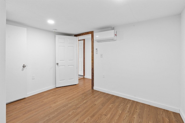 spare room with light hardwood / wood-style floors and a wall mounted AC