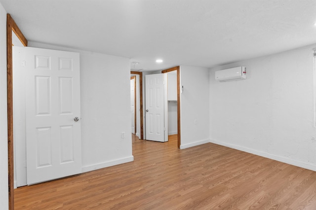 interior space featuring a wall mounted air conditioner and light hardwood / wood-style floors