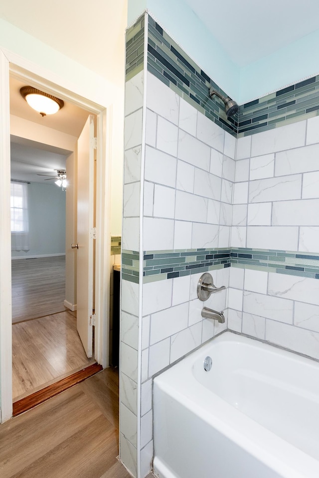 bathroom with hardwood / wood-style floors and a tub to relax in