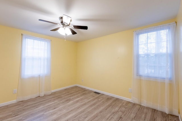 unfurnished room with ceiling fan, light hardwood / wood-style floors, and a healthy amount of sunlight