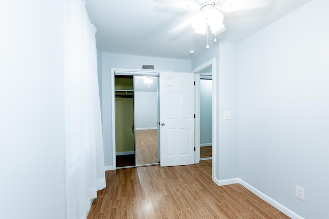 unfurnished bedroom with ceiling fan, a closet, and light hardwood / wood-style flooring