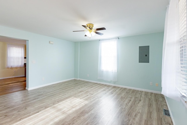 unfurnished room with ceiling fan, light wood-type flooring, and electric panel