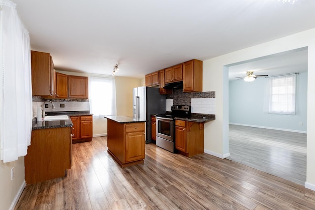 kitchen featuring appliances with stainless steel finishes, a center island, sink, and plenty of natural light