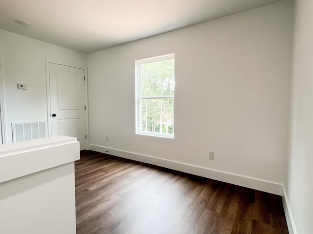 empty room with dark wood-type flooring