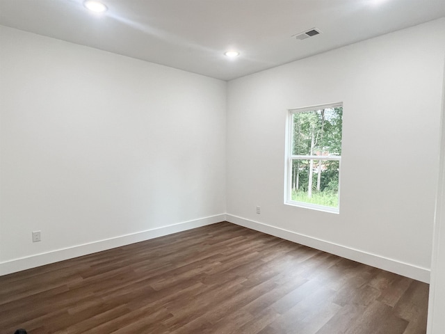 empty room with dark hardwood / wood-style flooring