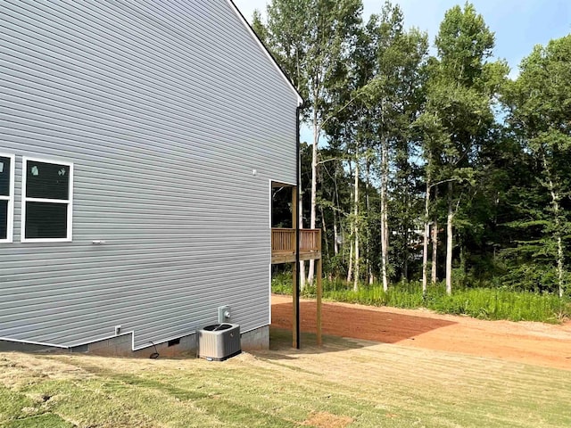 view of side of home featuring a yard and central air condition unit