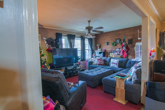 carpeted living room featuring ceiling fan, ornamental molding, and brick wall