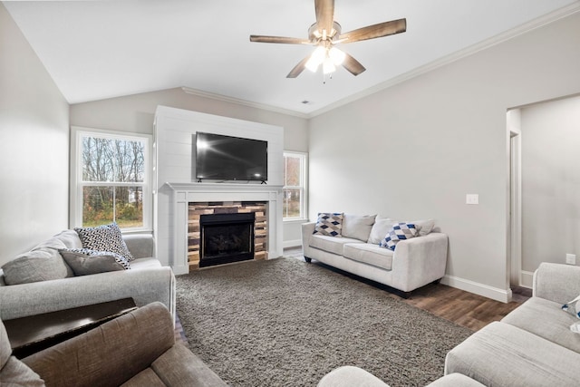 living room featuring crown molding, vaulted ceiling, dark hardwood / wood-style floors, ceiling fan, and a fireplace