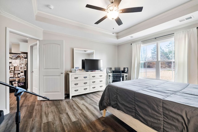 bedroom with ceiling fan, light wood-type flooring, crown molding, and a tray ceiling