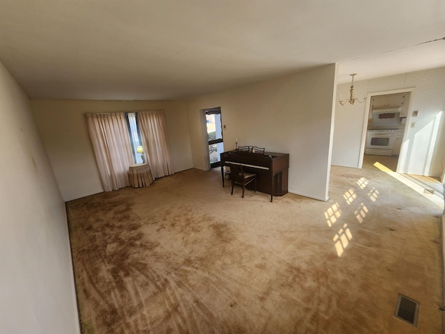 misc room with carpet floors and a chandelier