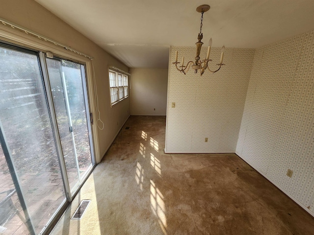 unfurnished dining area featuring a notable chandelier and carpet floors