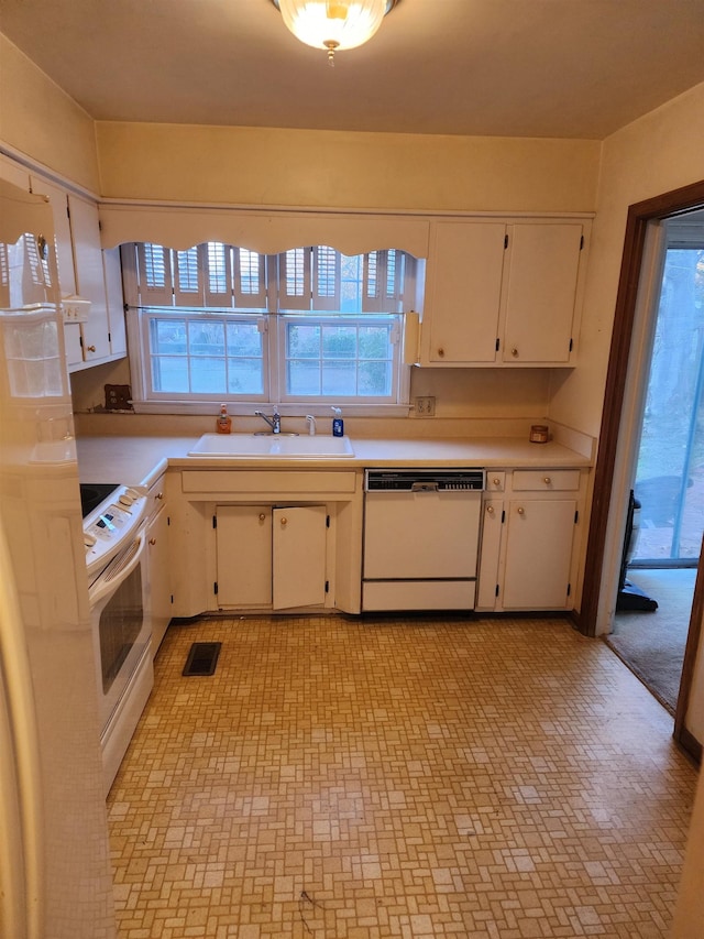 kitchen featuring white appliances, white cabinetry, and sink