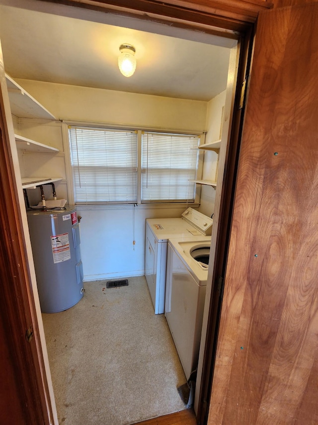 washroom with washer and dryer, electric water heater, and light colored carpet