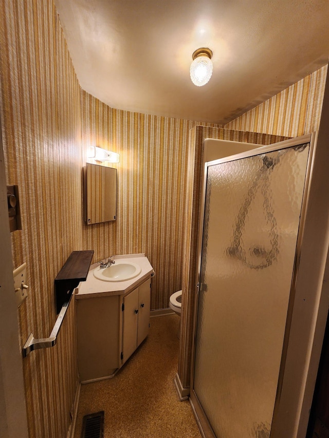 bathroom featuring vanity, toilet, and an enclosed shower