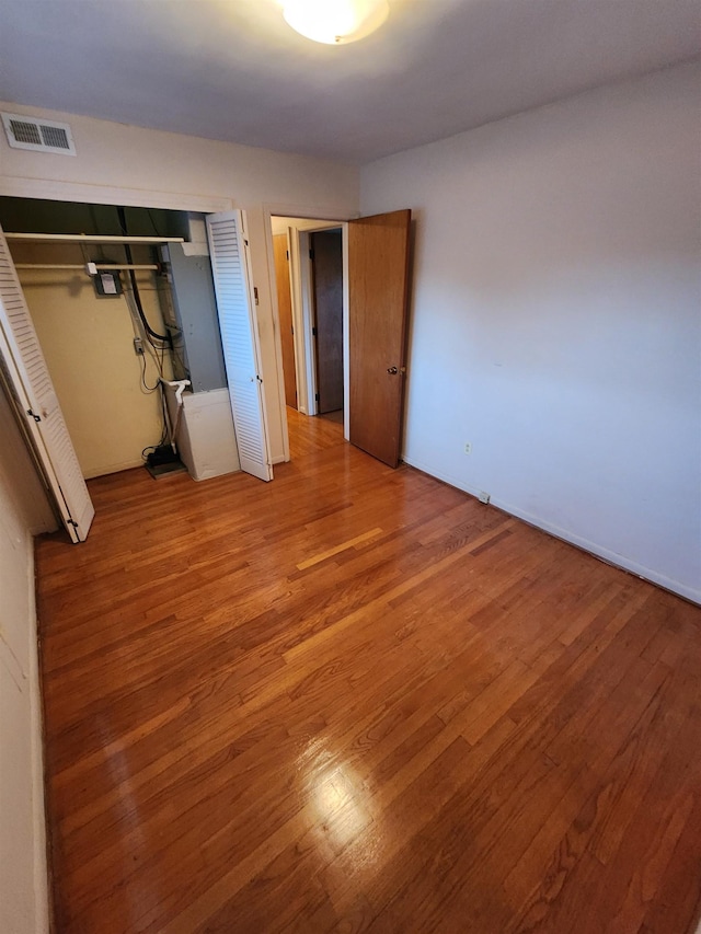 unfurnished bedroom with a closet and wood-type flooring