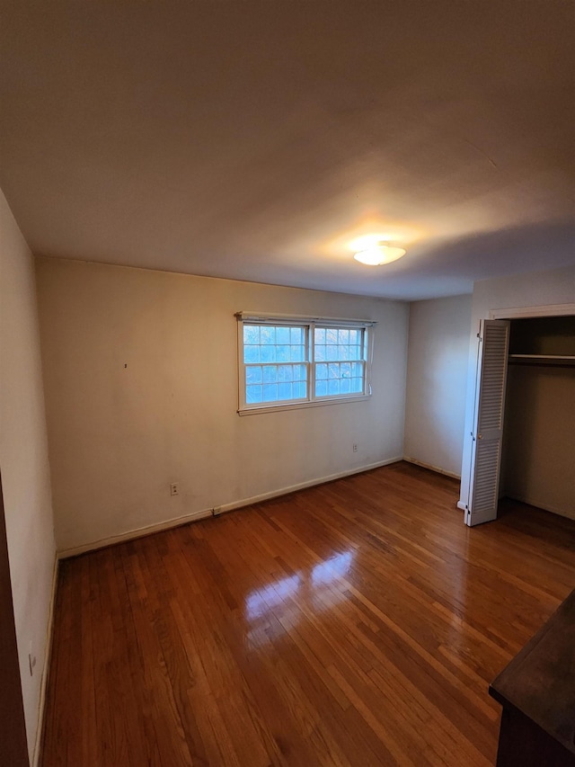 unfurnished bedroom featuring hardwood / wood-style flooring and a closet