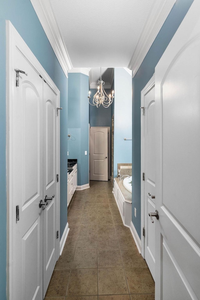 bathroom featuring ornamental molding, vanity, a bath, an inviting chandelier, and tile patterned flooring