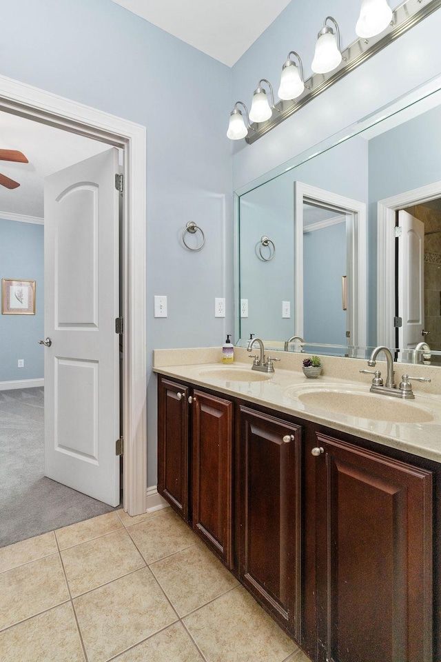 bathroom featuring tile patterned flooring, ceiling fan, crown molding, and vanity