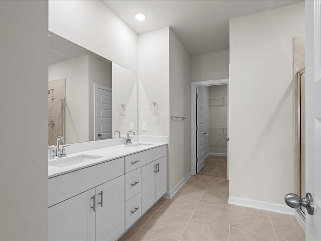 bathroom featuring tile patterned flooring, vanity, and a shower with door