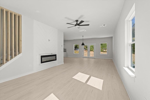 unfurnished living room with french doors, light wood-type flooring, and ceiling fan