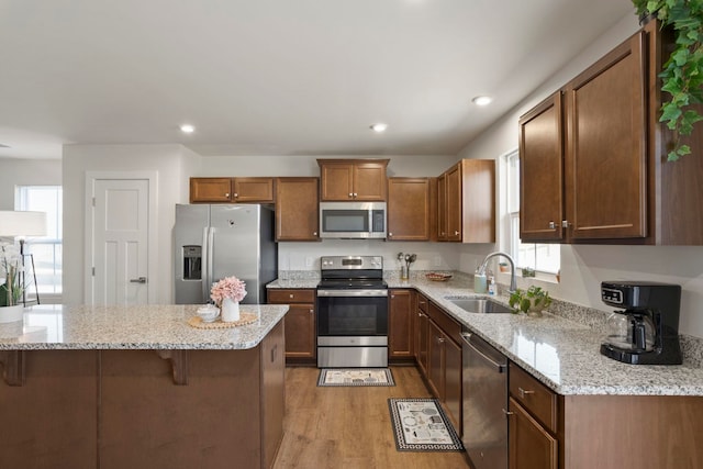 kitchen featuring stainless steel appliances, light hardwood / wood-style flooring, a wealth of natural light, and sink