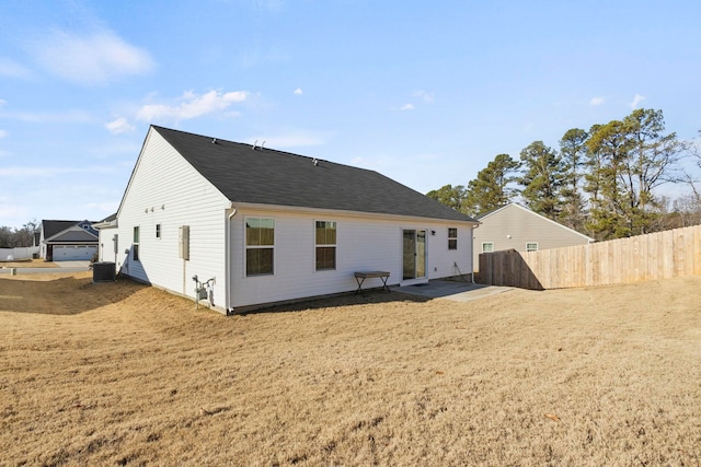 back of property with a lawn, a patio area, and central AC