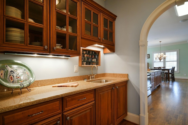 kitchen with sink, light stone counters, dark hardwood / wood-style flooring, a notable chandelier, and decorative light fixtures