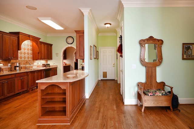 kitchen featuring decorative backsplash, light hardwood / wood-style floors, dishwasher, and crown molding