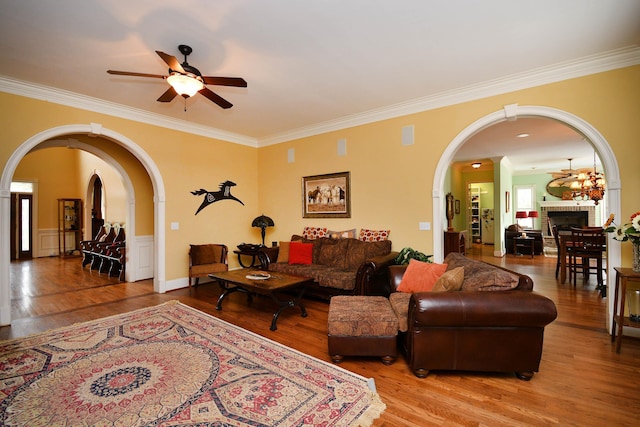 living room featuring a fireplace, hardwood / wood-style flooring, ceiling fan, and ornamental molding