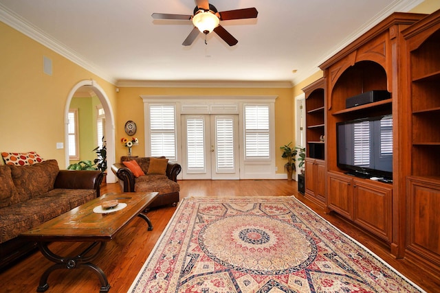 living room featuring ceiling fan, light wood-type flooring, ornamental molding, and french doors