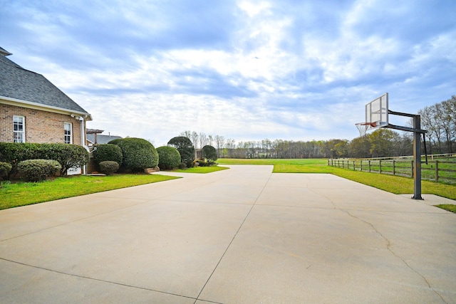 view of sport court with a lawn