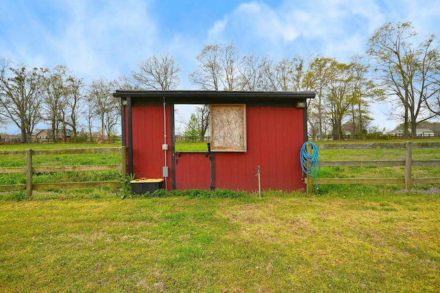 view of outdoor structure with a lawn and a rural view