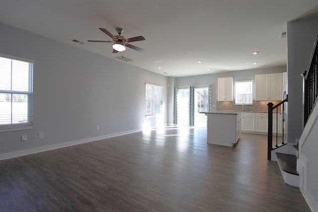 unfurnished living room featuring ceiling fan and hardwood / wood-style floors