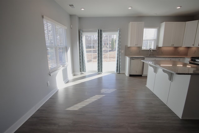 kitchen with a breakfast bar, white cabinetry, stainless steel appliances, and dark wood-type flooring