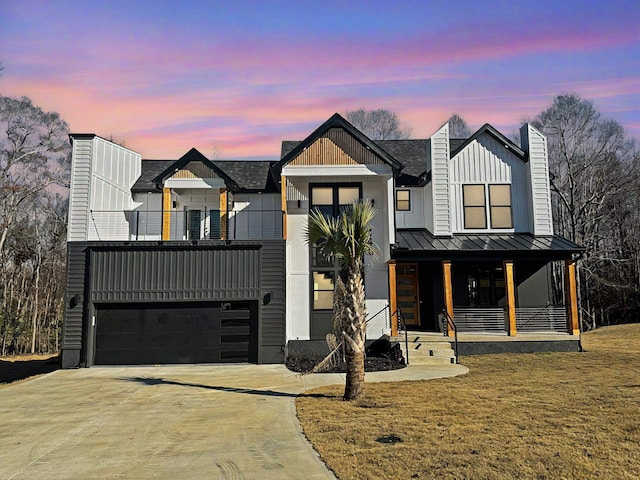 modern farmhouse style home with a porch, a yard, a balcony, and a garage