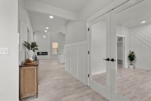 corridor with french doors and light hardwood / wood-style flooring