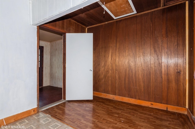 unfurnished bedroom featuring dark hardwood / wood-style floors, wooden walls, and wood ceiling