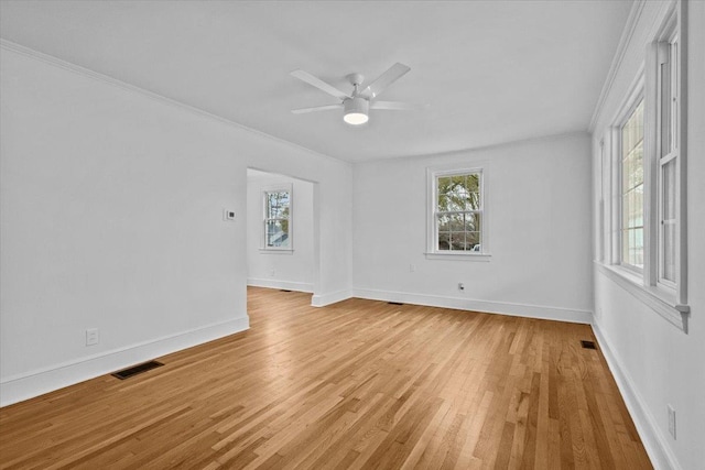 empty room with ceiling fan, crown molding, and light wood-type flooring