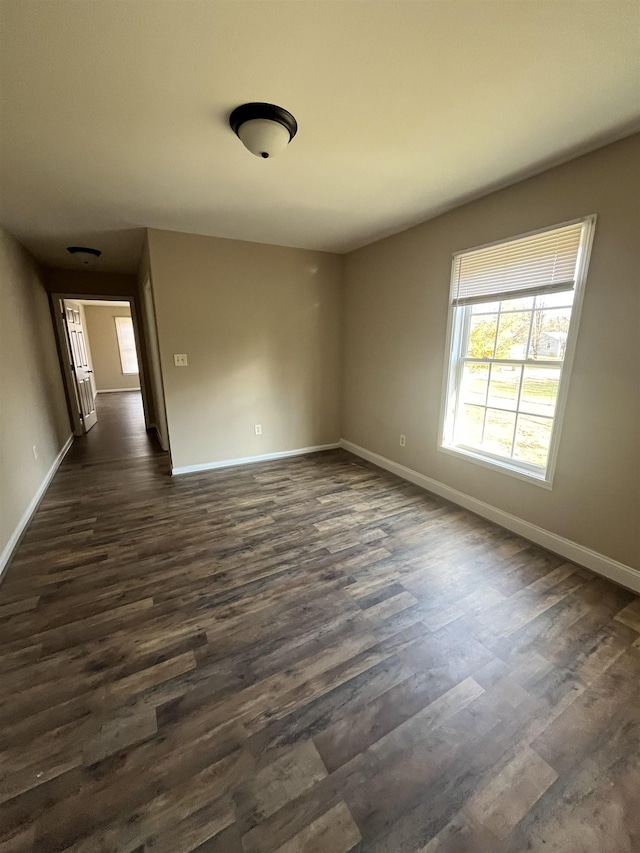 unfurnished room with dark wood-type flooring