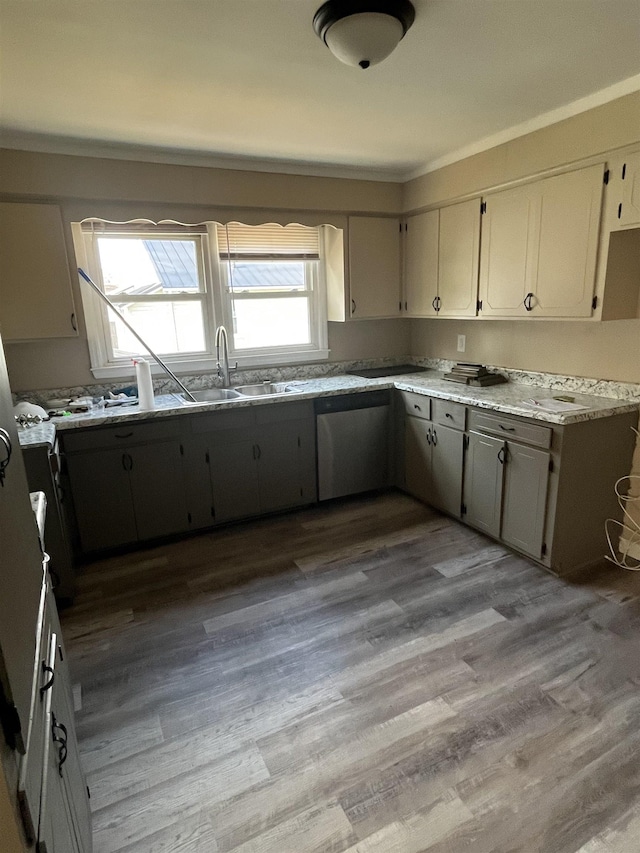 kitchen featuring gray cabinetry, light hardwood / wood-style floors, stainless steel dishwasher, and ornamental molding