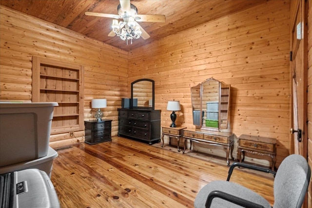 sitting room with light hardwood / wood-style flooring, rustic walls, ceiling fan, and wooden ceiling