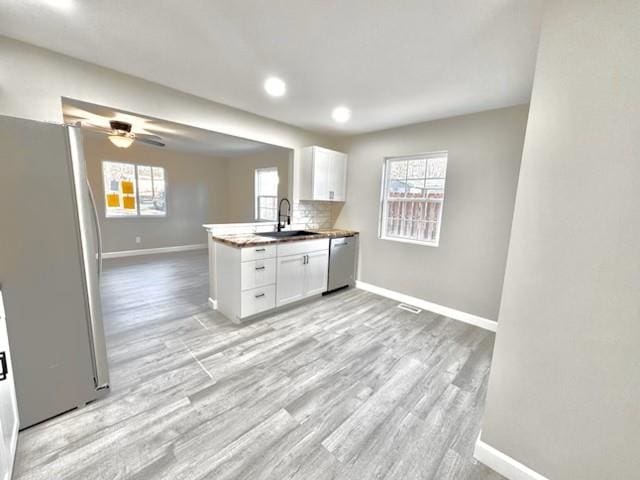 kitchen featuring appliances with stainless steel finishes, tasteful backsplash, ceiling fan, sink, and white cabinetry